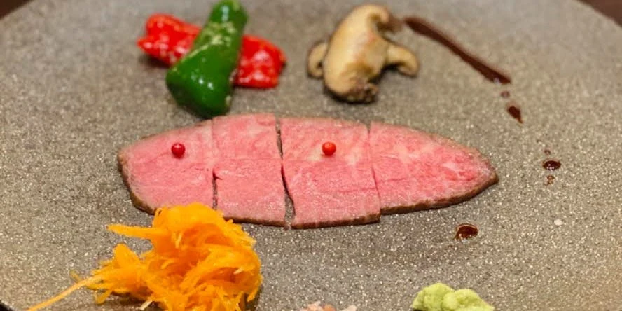 石皿に盛られた牛肉のたたきと彩り野菜
